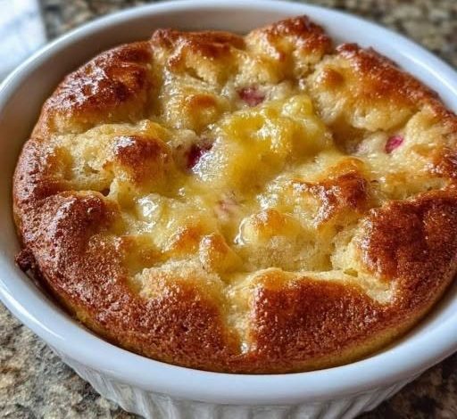 Golden baked cottage cheese breakfast bake in a white ramekin with a fluffy cheesy center and crispy golden edges.